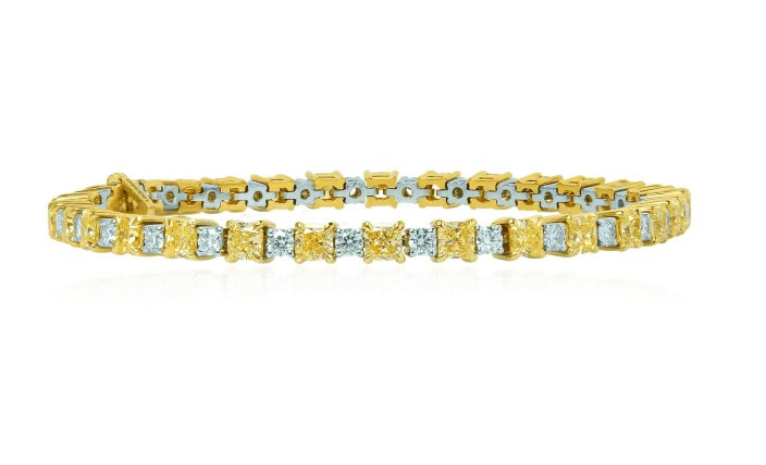 A stunning 8.37 ct TW Fancy Yellow radiant and collection white diamond bracelet mounted in 18K white and yellow gold.